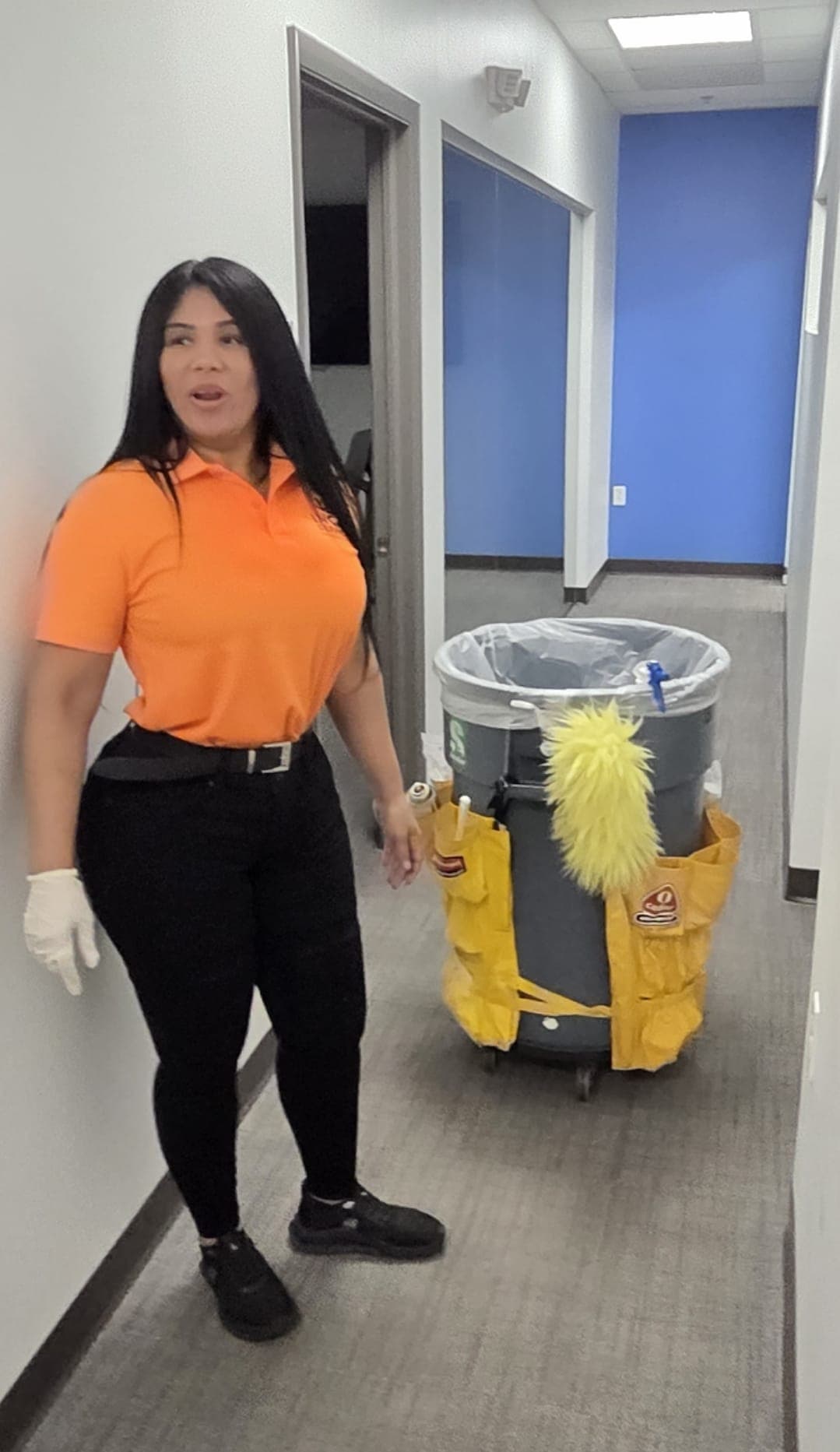 INGAL SERVICES INC employee standing with a fully stocked janitorial cart in a client corridor
