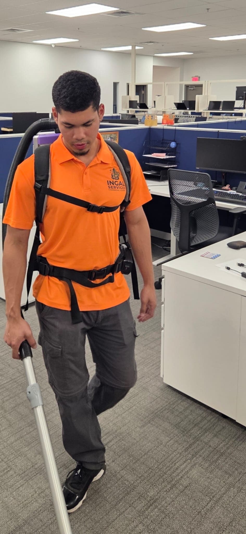 INGAL SERVICES INC employee using a backpack vacuum between office cubicles