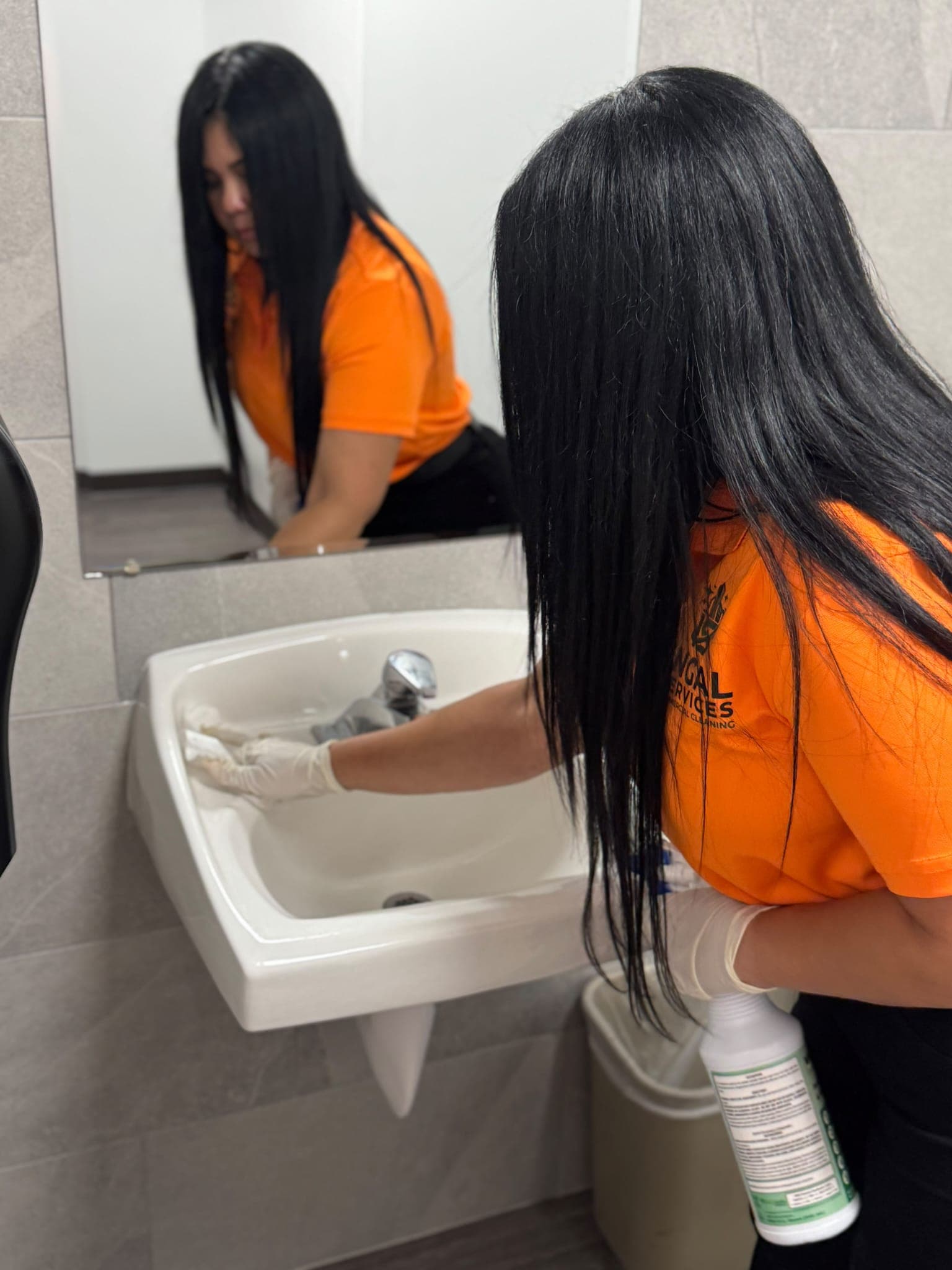 INGAL SERVICES INC employee detailing a restroom sink and chrome fixtures