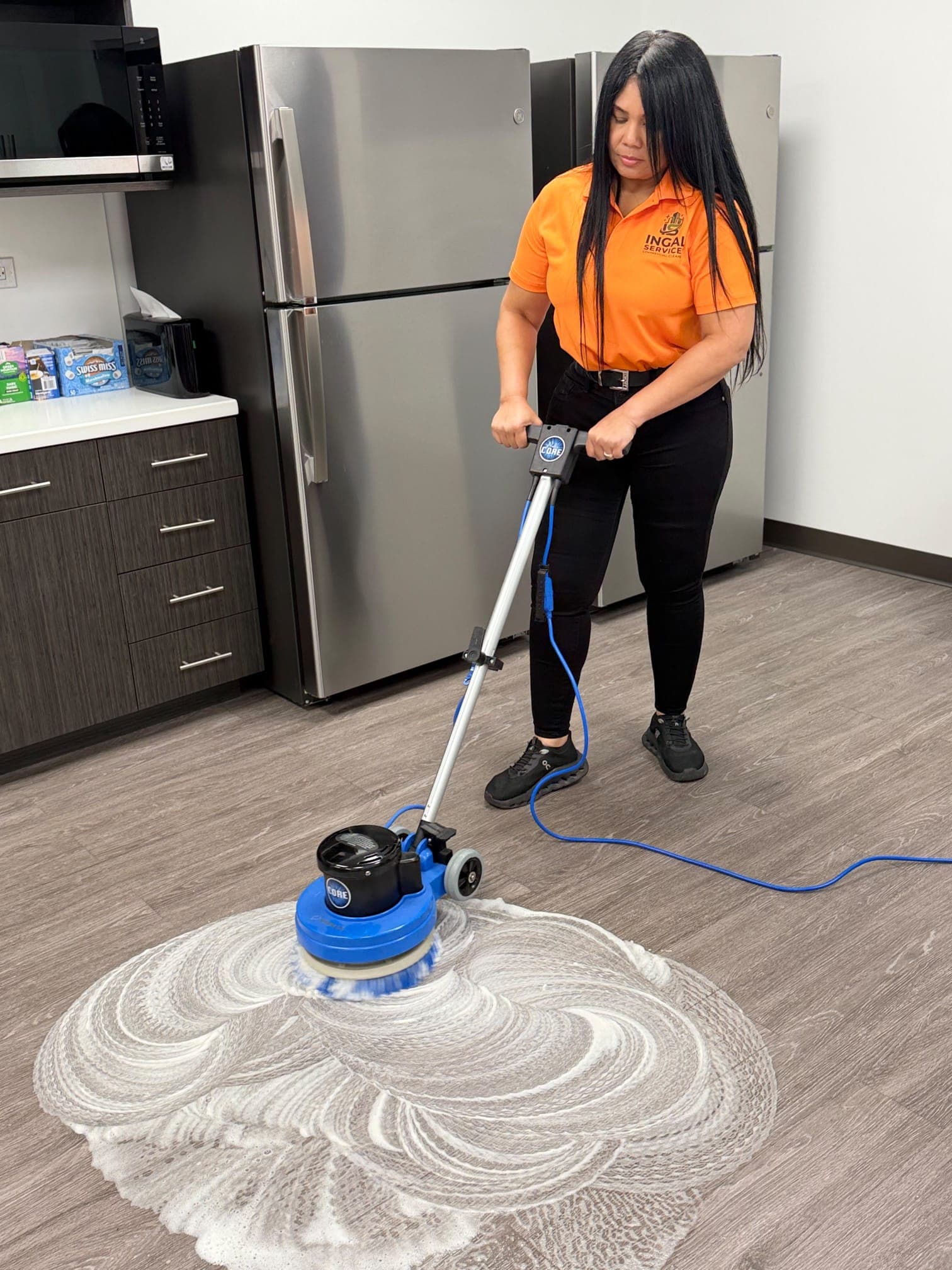 INGAL SERVICES INC employee operating a rotary floor machine to scrub breakroom flooring