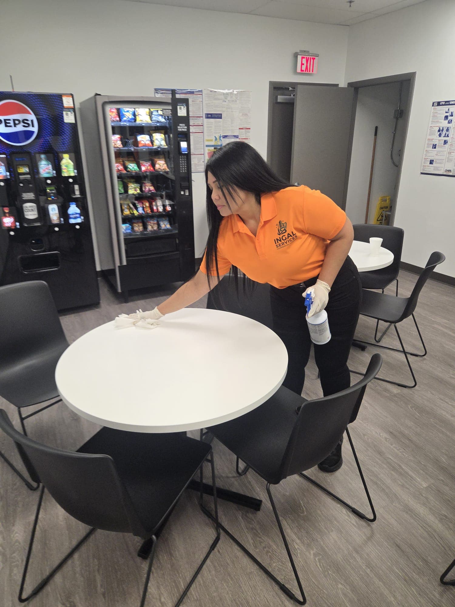 INGAL SERVICES INC employee sanitizing tables in an employee break area beside vending machines