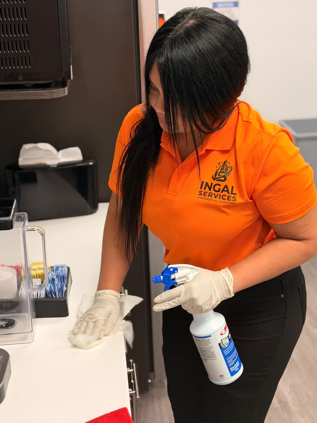 INGAL SERVICES INC employee wiping down a breakroom counter with glass cleaner