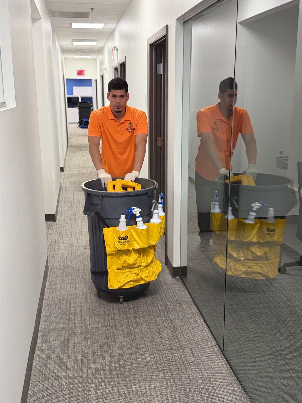 INGAL SERVICES INC employee moving a stocked janitorial cart through an office corridor